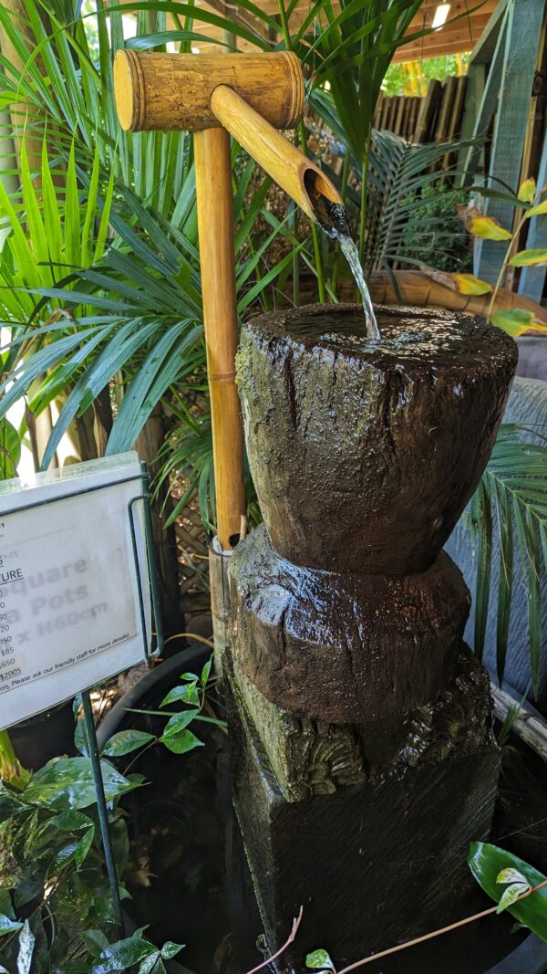 bamboo spout with water pouring into a stone bowl